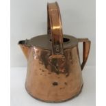 A large antique copper water jug with riveted swing handle and decorative handle brackets.