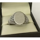 A men's silver signet ring with decoration to shoulders and empty oval shaped cartouche. Size X.