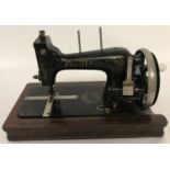 A vintage Printemps hand sewing machine with gilt detail, folding enamel handle & inlaid wooden base