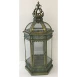 A large green metal ornamental free standing, hexagonal lantern.