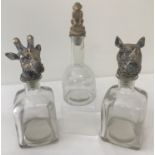 3 glass decanters with novelty animal shaped stoppers.