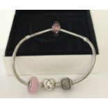 A silver Pandora charm bracelet with heart shaped catch complete with 3 charm beads.