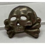 A WWII style Allgemeine SS Totenkopf skull and crossbones cap badge.