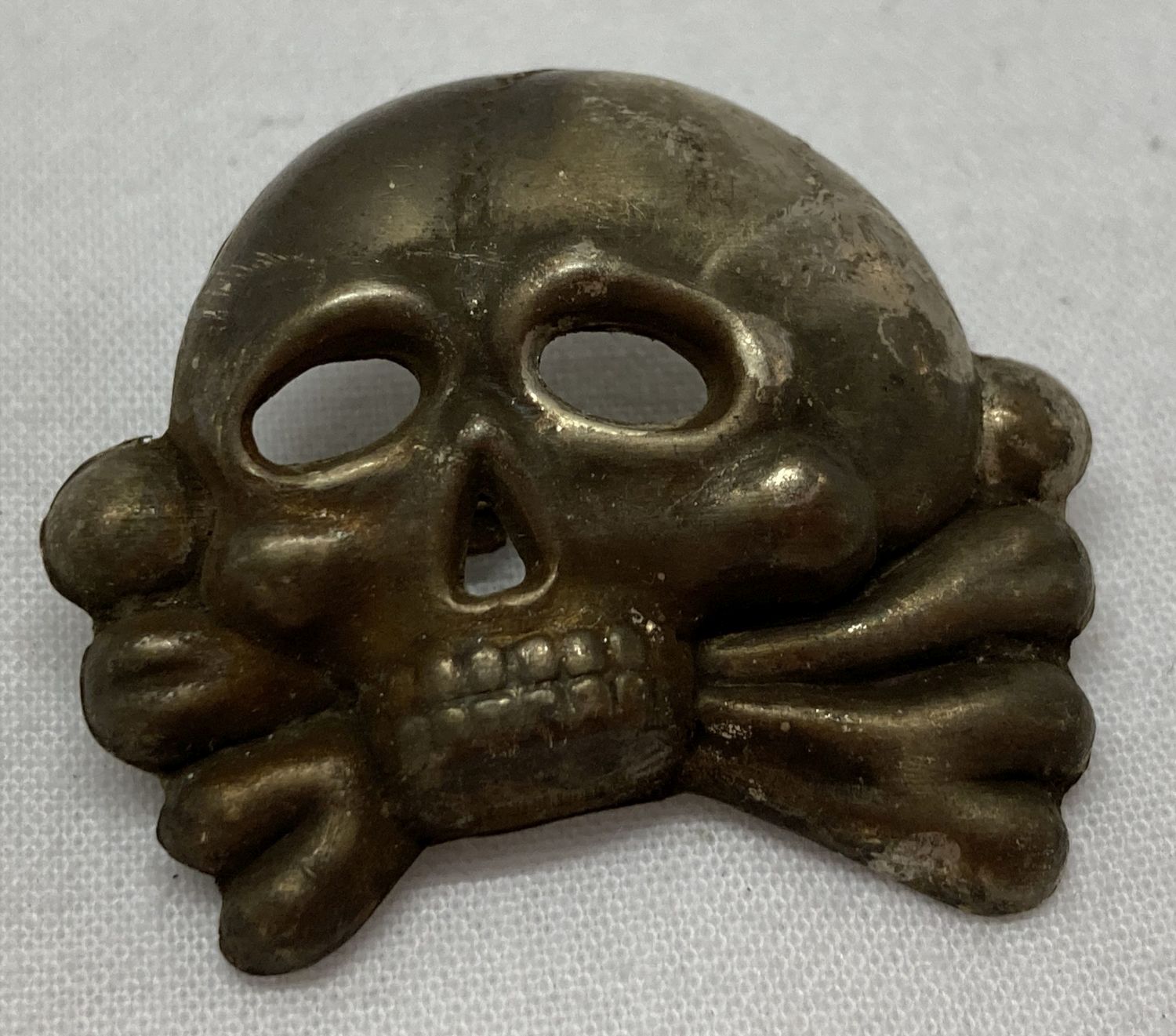 A German WWII style Allgemeine SS Totenkopf death head skull cap badge .