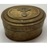A German WWII style N.S.K.K. trench art oval trinket tin with eagle and swastika detail to top.