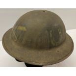 A WWI style British "Brodie" helmet with machine gun corps painted insignia.