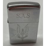 A chrome wind proof lighter engraved with SAS logo and motto.