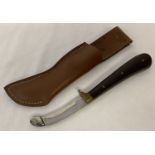 A gralloching knife with wooden grip complete with brown leather scabbard.