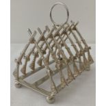 A decorative silver plated toast rack in the form of crossed guns.
