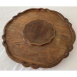 A wooden table top Lazy Susan with scalloped design edging.