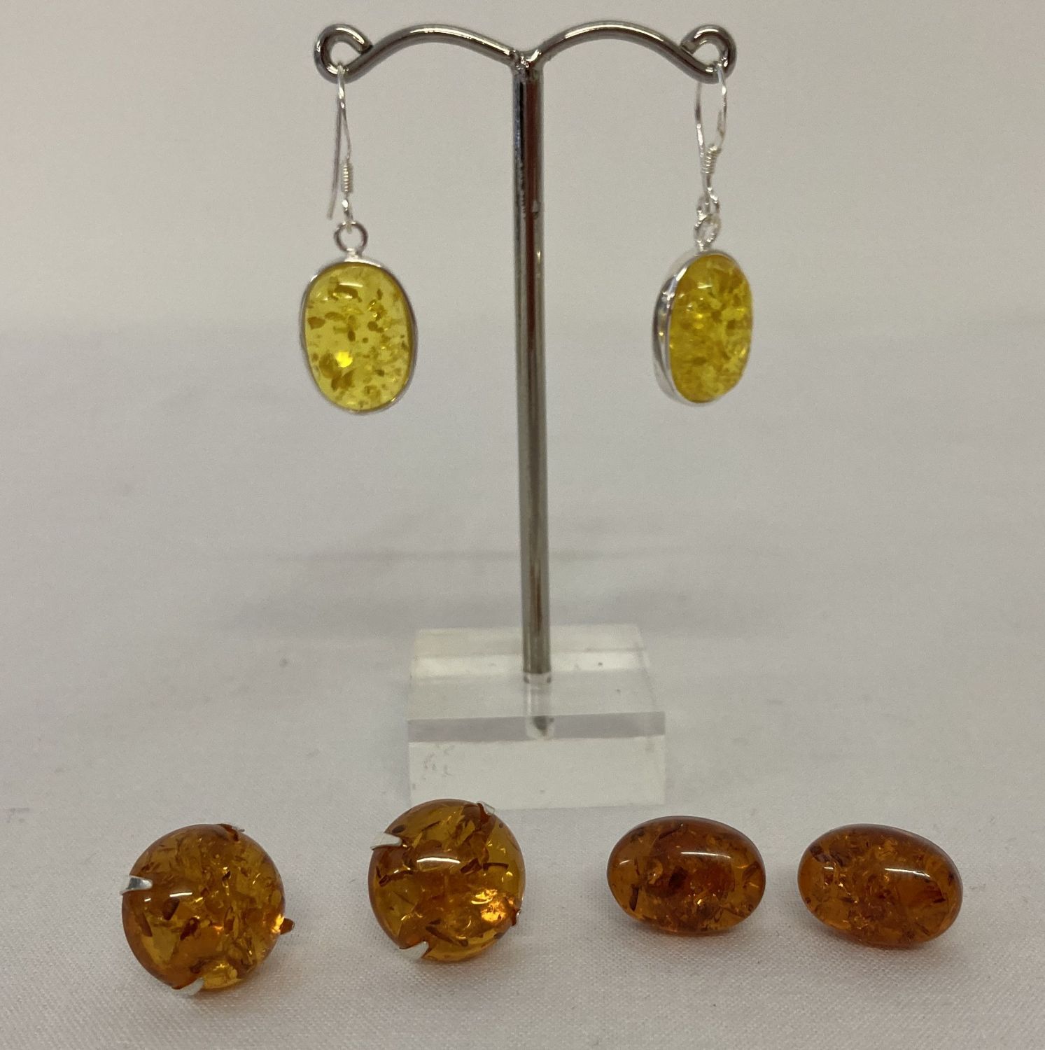 3 pairs of amber earrings; 2 pairs of studs together with a pair of yellow amber drop earrings.