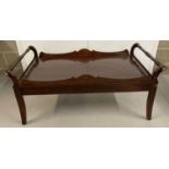 A large vintage dark wood coffee table with galleried top and turned handle design.