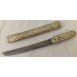 A Japanese Tanto sword with white metal cased sleeve and handle decorated in erotic scenes.