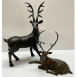 A vintage spelter figurine of a sitting stag together with a modern resin figurine.