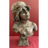 An Art Nouveau style bronze bust of a woman in period dress.