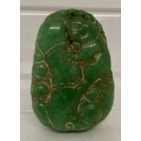 A carved Chinese green jade pendant.