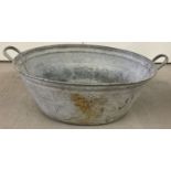 A vintage galvanised oval shaped, 2 handled bath.