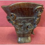 A Chinese carved libation cup with mythical creature detail.