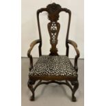 A Victorian dark wood high backed arm chair with carved back panel.