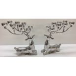 A pair of large modern stainless steel candlesticks in the form of Stags.