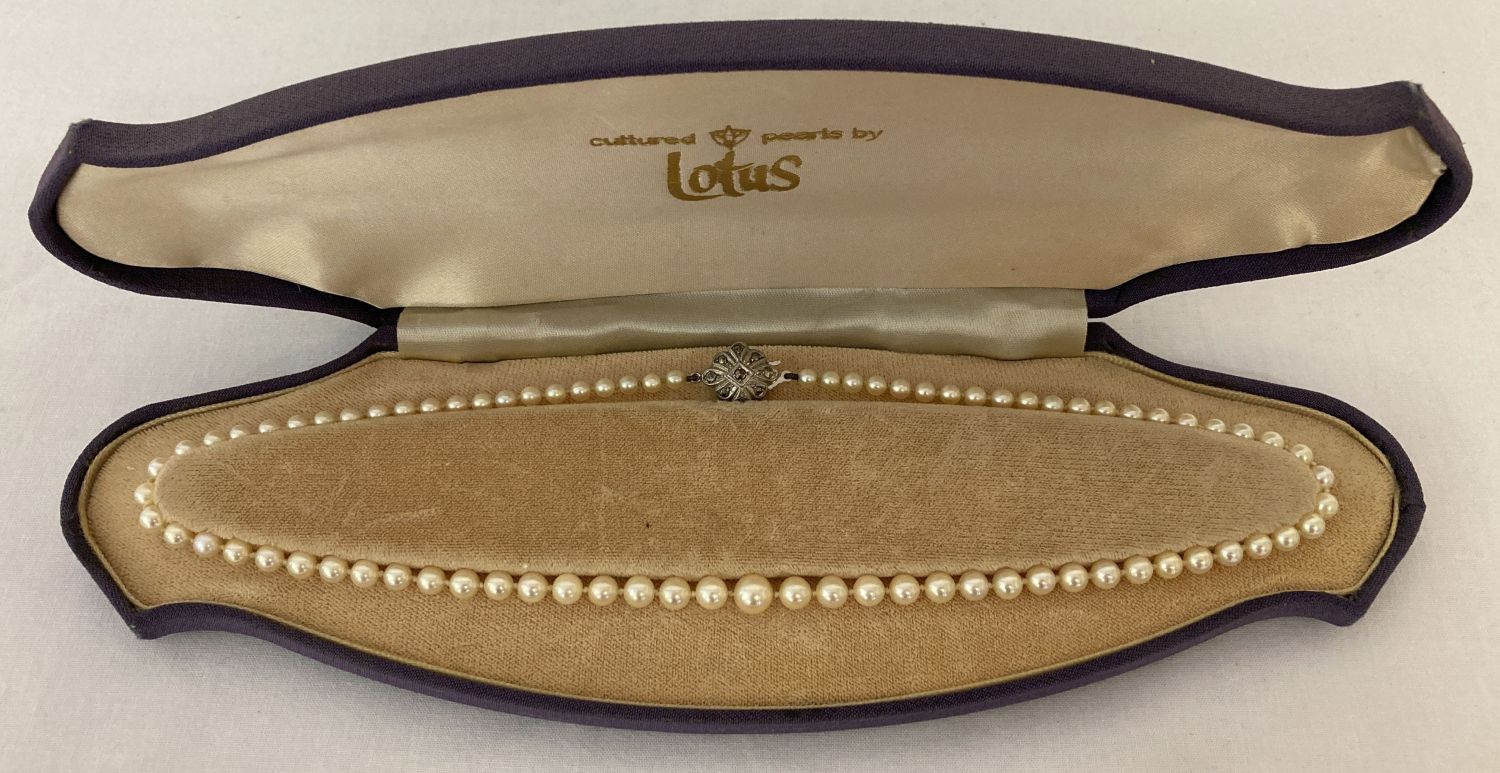 A vintage string of Lotus cultured pearls, with marcasite set silver clasp. In original box.
