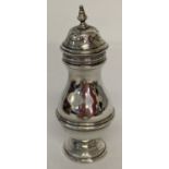 A vintage silver pepperette with turned finial design and engraved detail to lid.