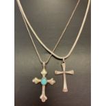 2 silver cross shaped pendants on chains.