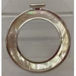 A large circular shaped double sided mother of pearl pendant.