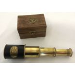 A leather and brass 3 draw telescope contained in a wooden box with brass anchor motif.