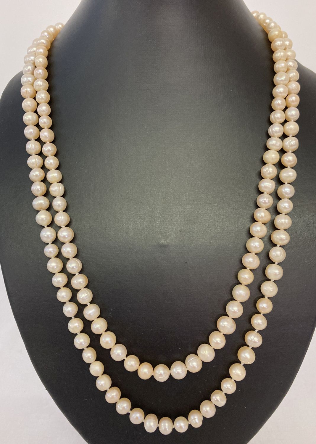 A 48" string of pale peach lustre freshwater pearls.