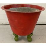 A vintage copper planter painted red on 3 cabriole style legs painted green.