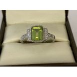 A 9ct white gold Art Deco style peridot and diamond dress ring probably by Luke Stockley, London.