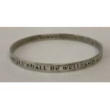 A silver bangle with engraved inscription by Julian of Norwich.