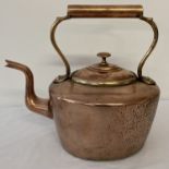 A vintage copper kettle with riveted handle and shaped spout.