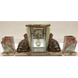 An Art Deco marble, onyx and spelter mantel clock garniture.