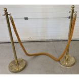 A pair of function posts with heavy gold coloured rope and brass hooks.