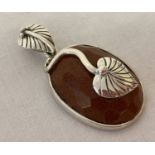 A silver and goldstone Art Nouveau style oval shaped pendant, with leaf shaped bale.
