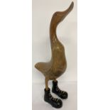 A wooden figurine of a duck wearing boots.