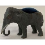 A cold painted pin cushion in the form of an elephant, with blue velvet cushion.