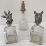 3 glass decanters with novelty animal shaped stoppers.