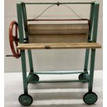 A vintage Triang toy mangle with original paintwork and replacement wooden shelves.