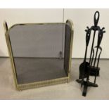 A pained black wrought iron companion set together with a decorative fire guard