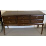 A dark wood 6 drawer dressing table by Stag. With drop down circular handles.