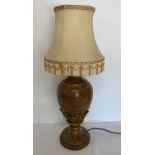 A gold coloured table lamp with leaf decoration and cream shade.