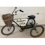 A vintage 3 wheeled tricycle with central advertising panel.