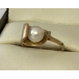 A contemporary design 9ct gold ring set with a single pearl.