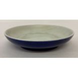 A Chinese porcelain shallow dish with deep blue glaze to outer bowl.