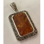 A rectangular shaped mounted amber pendant framed with marcasite's.