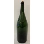 A very large vintage green glass wine bottle.