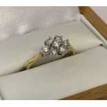 A 18ct gold and diamond set flower head design dress ring. 7 round cut diamonds totalling .35ct.